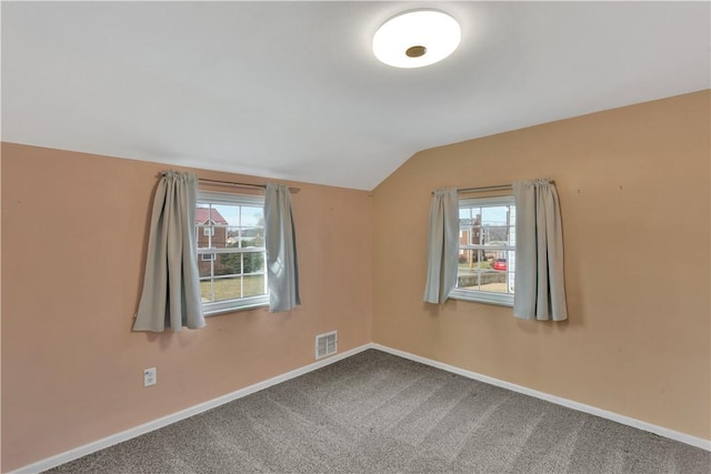 carpeted spare room with lofted ceiling and a wealth of natural light