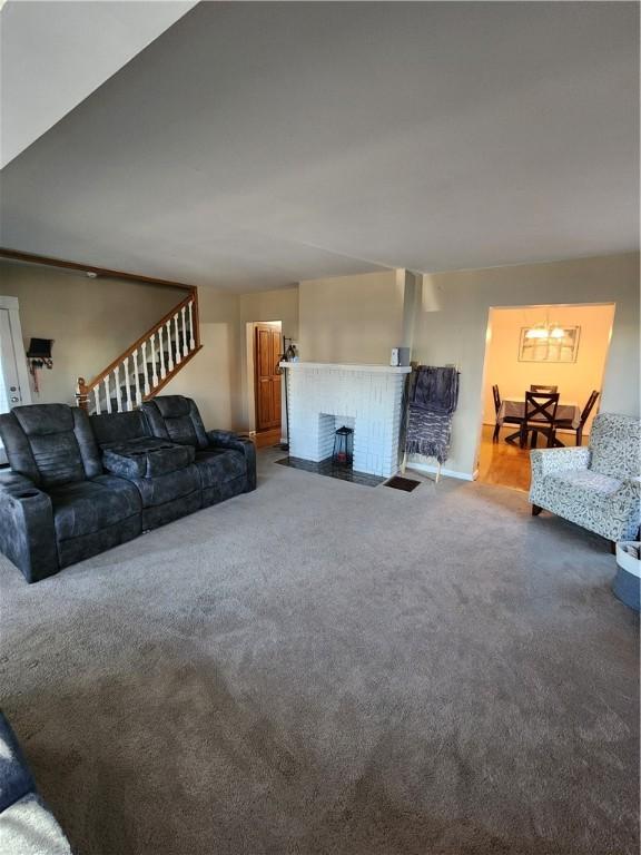 living room featuring carpet and a brick fireplace