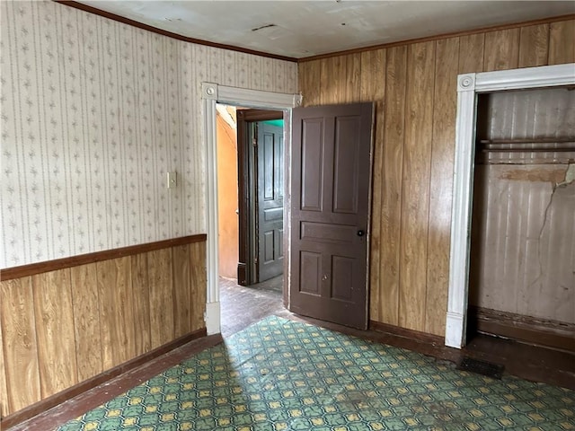 interior space with crown molding and wood walls