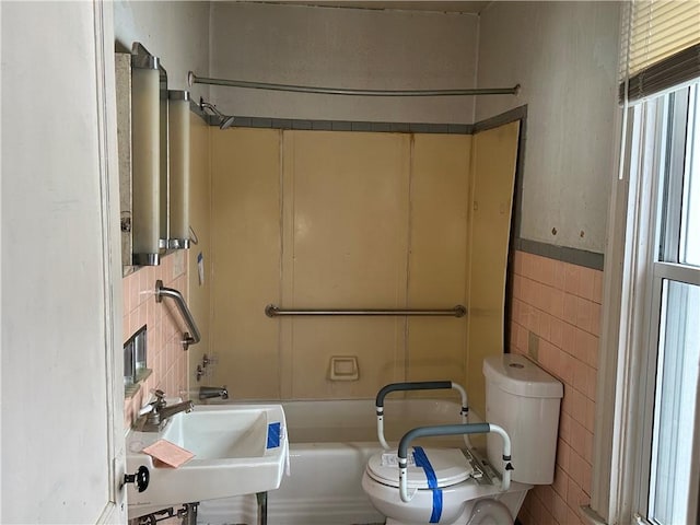 full bathroom featuring  shower combination, toilet, sink, and tile walls