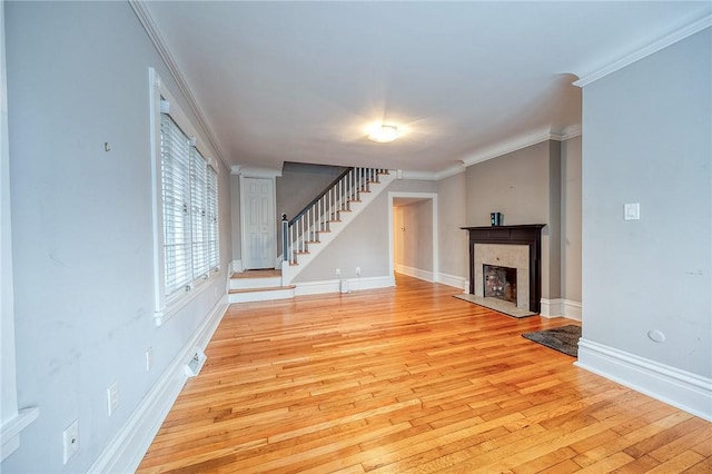 unfurnished living room with crown molding and light wood-type flooring