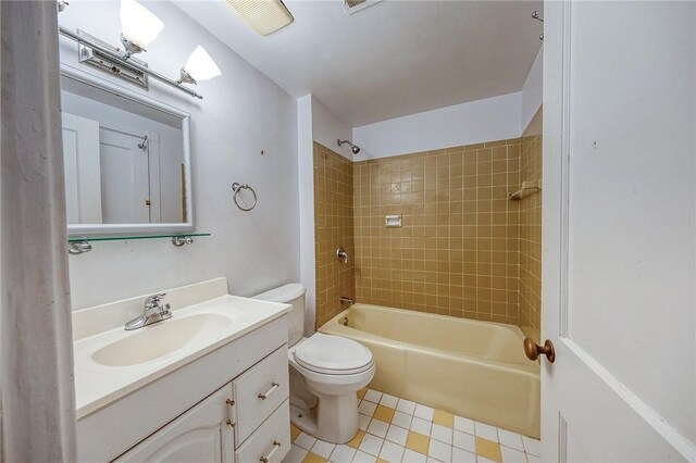 full bathroom with vanity, tiled shower / bath combo, and toilet