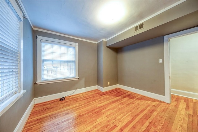 empty room featuring ornamental molding and light hardwood / wood-style floors