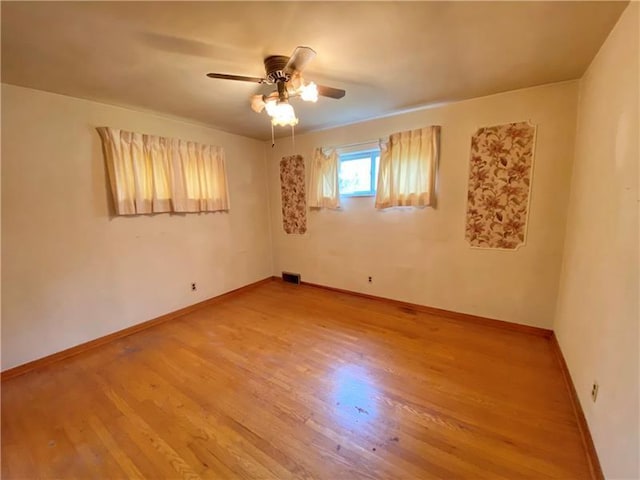 empty room with hardwood / wood-style floors and ceiling fan