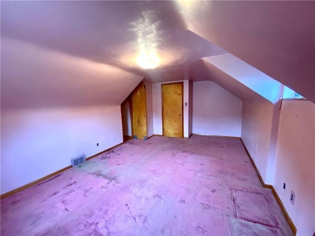 additional living space with light carpet and vaulted ceiling