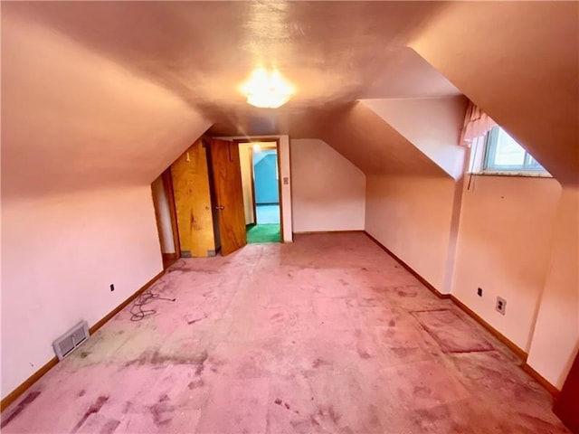 additional living space with carpet floors and vaulted ceiling