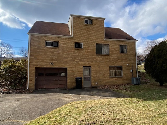 exterior space featuring a yard, a garage, and central AC