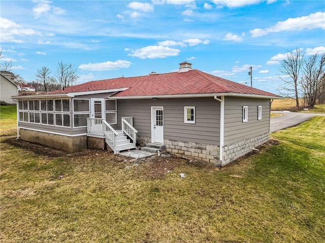 rear view of property featuring a sunroom and a yard