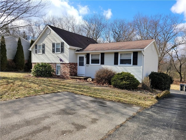 tri-level home featuring a front lawn