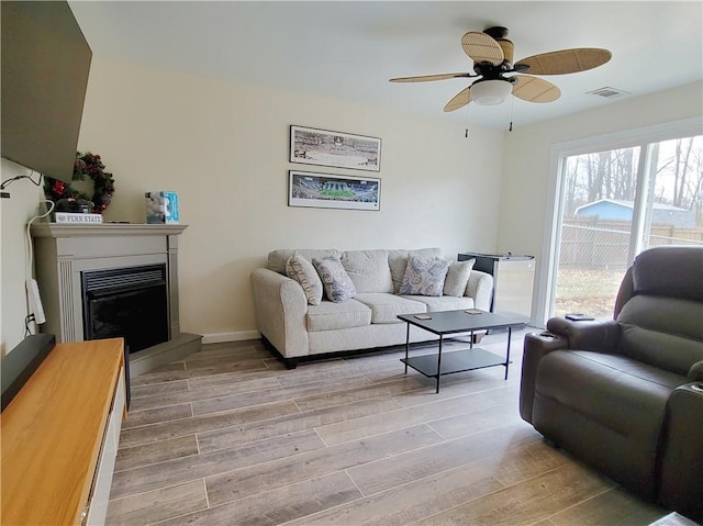 living room with ceiling fan and light wood-type flooring