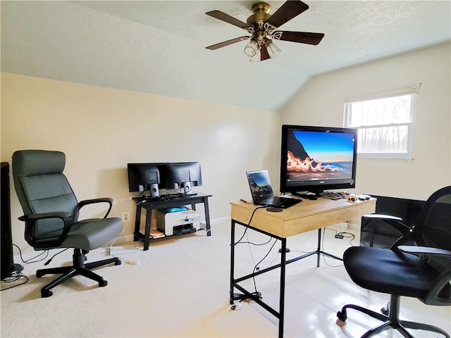 office space with lofted ceiling, ceiling fan, carpet floors, and a textured ceiling