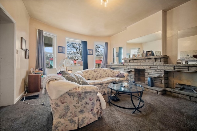 carpeted living room with a stone fireplace