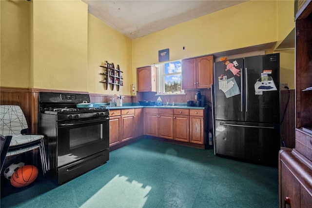 kitchen with fridge, black gas stove, and sink