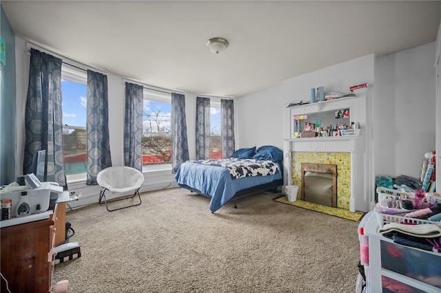 carpeted bedroom featuring a tiled fireplace