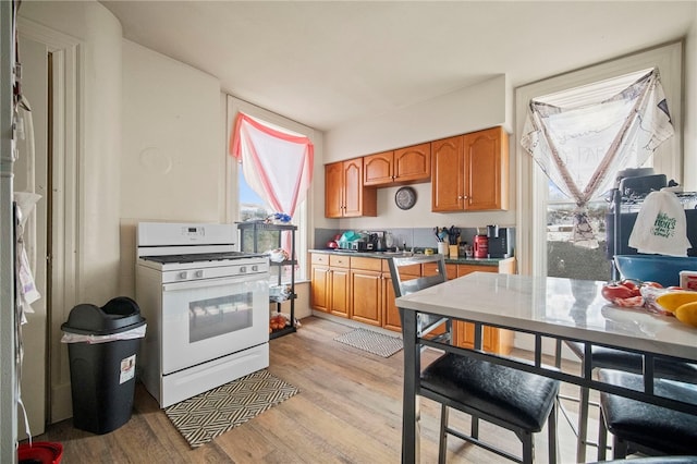 kitchen featuring white gas range and light hardwood / wood-style flooring