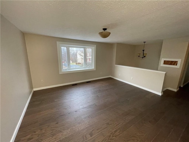 unfurnished room with dark hardwood / wood-style floors and a textured ceiling