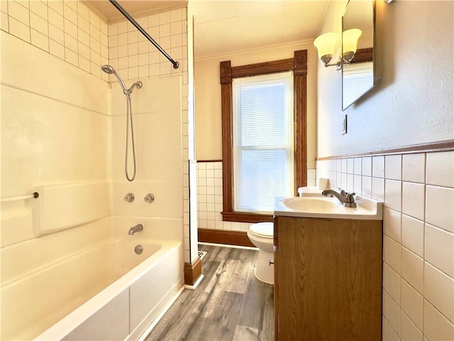 full bath featuring wainscoting, toilet, wood finished floors, vanity, and tile walls