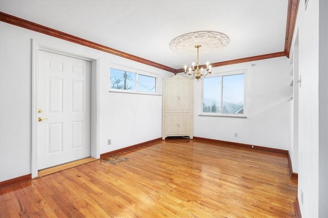 interior space featuring ornamental molding, an inviting chandelier, and light wood-type flooring