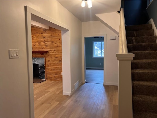 corridor with hardwood / wood-style floors and wood walls