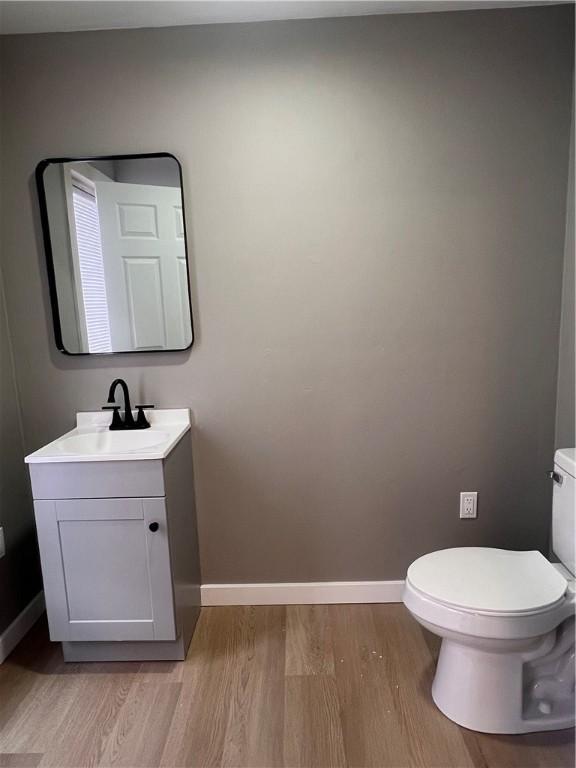 bathroom featuring vanity, hardwood / wood-style flooring, and toilet