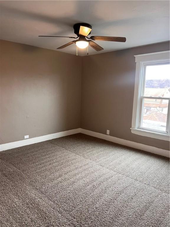 unfurnished room featuring ceiling fan and carpet flooring