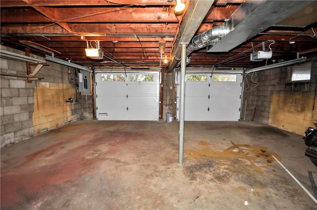 garage with a garage door opener and electric panel