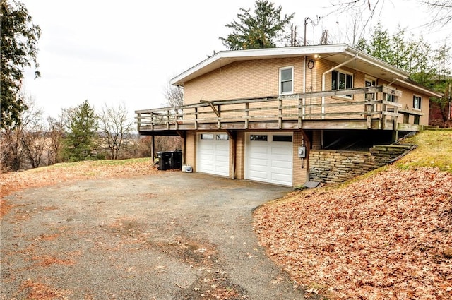 view of side of home with a wooden deck and a garage