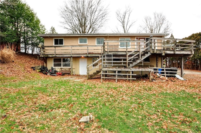 rear view of house with a wooden deck and a yard