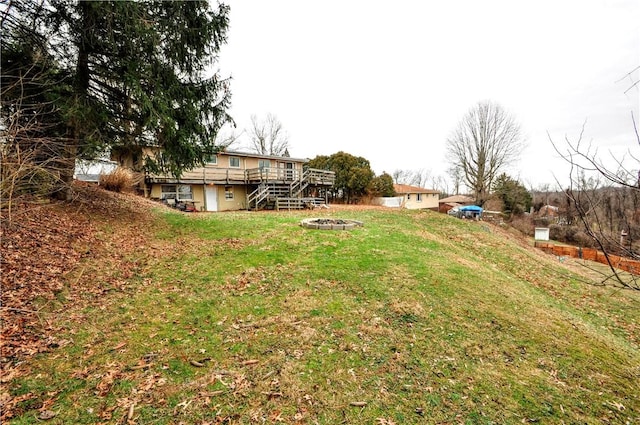 view of yard with a wooden deck and a fire pit