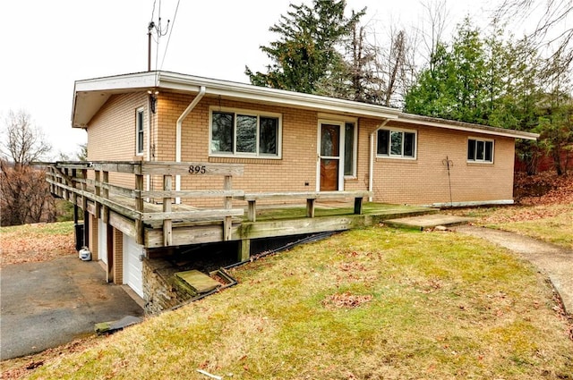 view of front facade featuring a garage, a deck, and a front lawn