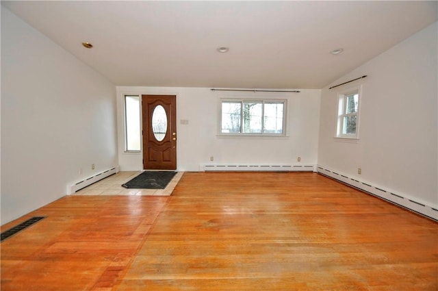 entrance foyer with a baseboard radiator and lofted ceiling