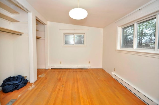 unfurnished bedroom with a baseboard radiator and light hardwood / wood-style flooring