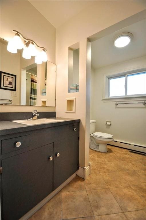 bathroom with a baseboard radiator, vanity, toilet, and tile patterned floors