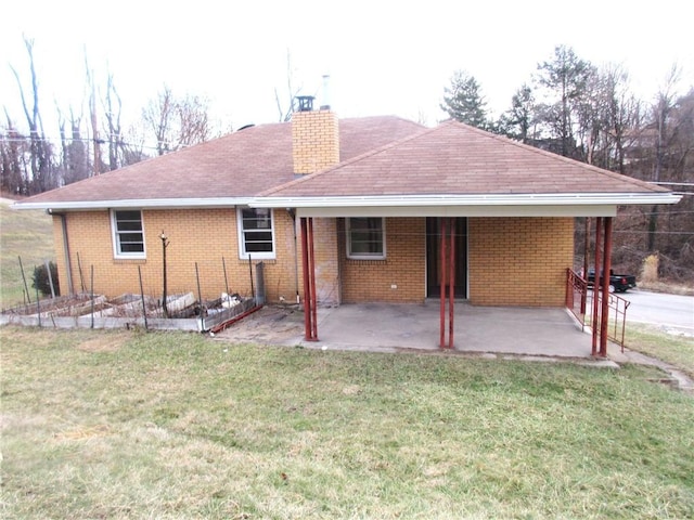 back of property with a lawn and a patio area