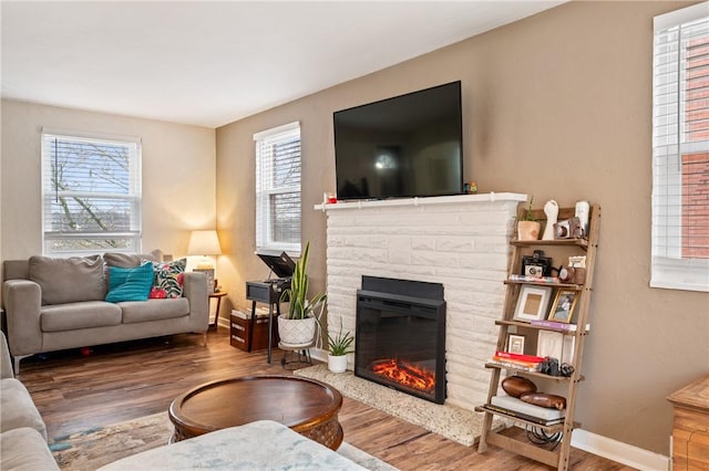 living room featuring a stone fireplace and hardwood / wood-style floors