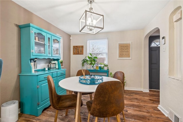 dining area featuring an inviting chandelier and dark wood-type flooring