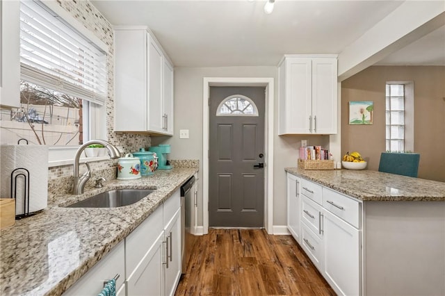 kitchen featuring sink, dark hardwood / wood-style flooring, light stone countertops, decorative backsplash, and white cabinets