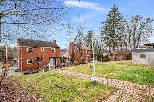 rear view of property featuring a storage shed and a yard