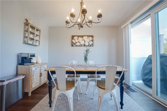 dining room with dark hardwood / wood-style flooring and a chandelier