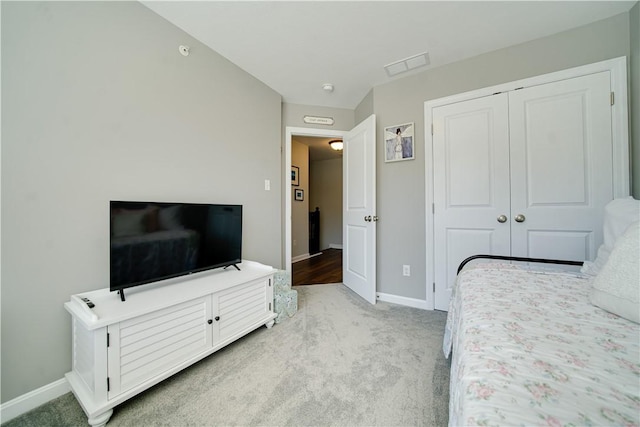 bedroom with light colored carpet and a closet