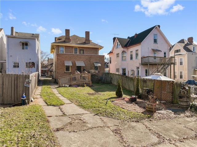 rear view of property with a deck and a lawn