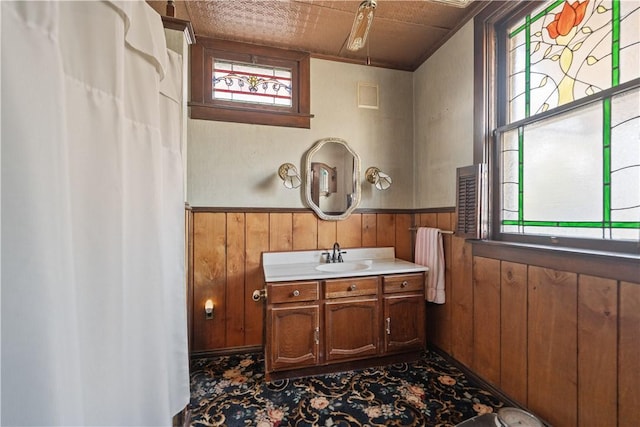 bathroom with vanity and wooden walls