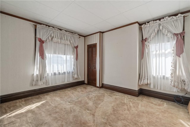 carpeted empty room with baseboard heating and ornamental molding