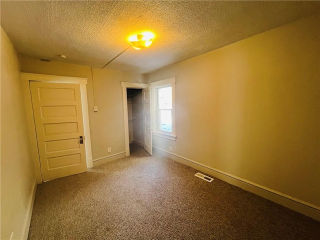 unfurnished bedroom with carpet floors, a textured ceiling, and a closet