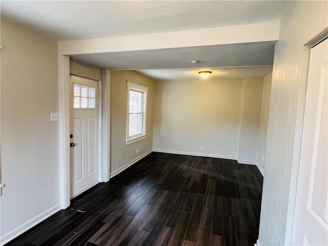 entryway with dark hardwood / wood-style flooring and a textured ceiling