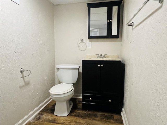 bathroom with wood-type flooring, toilet, and vanity