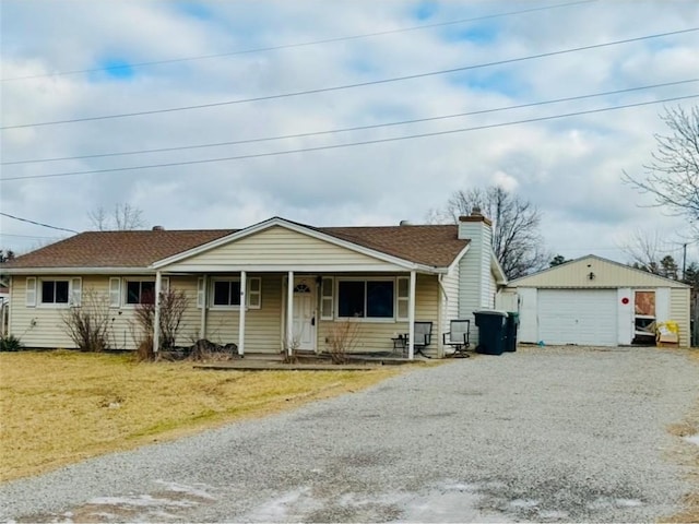 view of front facade with an outbuilding, a garage, a front yard, and covered porch