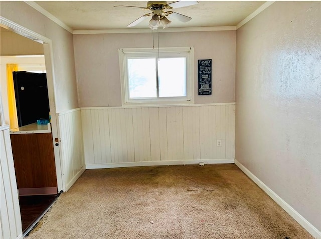 empty room featuring ornamental molding, carpet, and ceiling fan