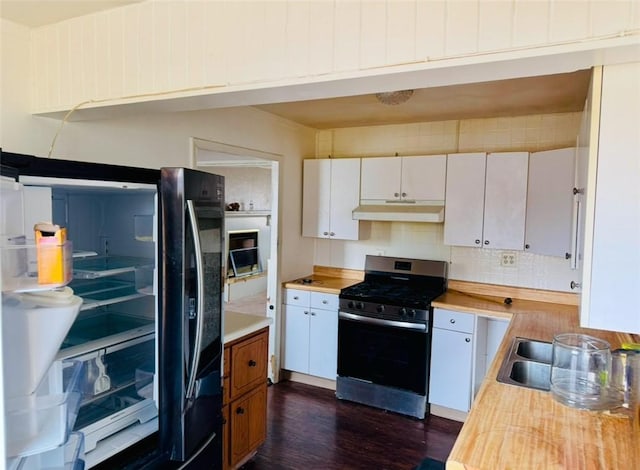 kitchen featuring butcher block countertops, white cabinets, dark hardwood / wood-style flooring, black fridge, and stainless steel gas range