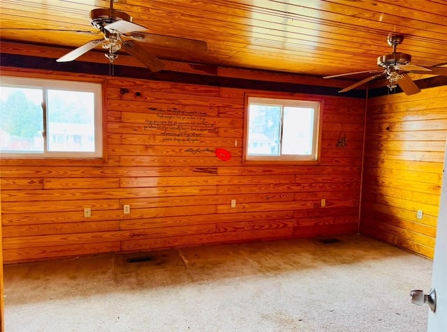 unfurnished room with carpet, a wealth of natural light, wood ceiling, and wooden walls